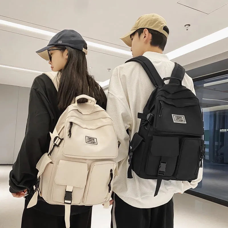 Black and white nylon student backpack with laptop compartment and three-dimensional outer pockets.