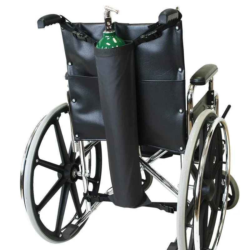 Black cylindrical Oxford cloth pannier bag attached to a wheelchair for oxygen cylinder storage.