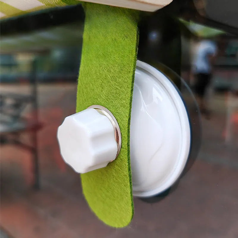 Foldable wooden cat window hammock with suction cups attached to a glass pane.