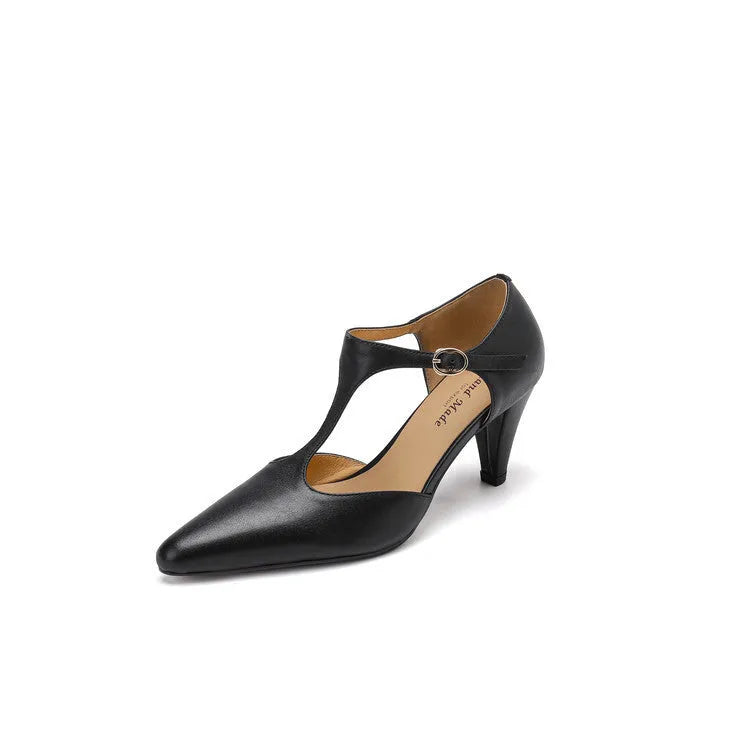 Brown retro women's T-strap sandals with a closed toe, low upper, and a stout high heel on a wooden floor.