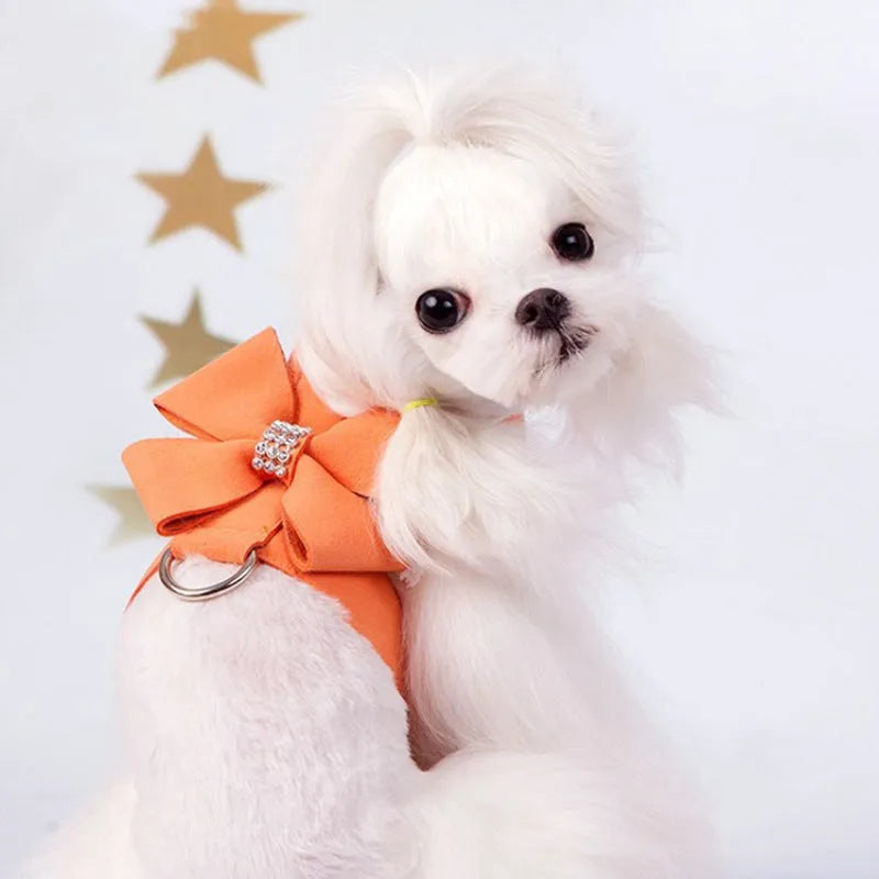 A pink microfiber puppy chest strap harness with a large bowknot, shown on a small dog.