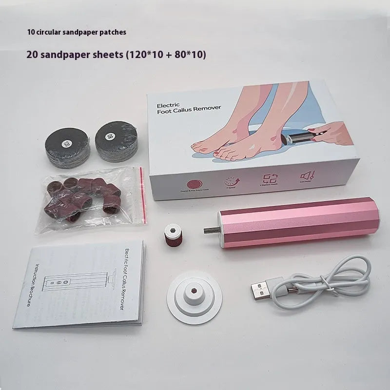 Pink electric callus remover tool with USB cable and pack of sandpaper grinding wheel attachments on a table.