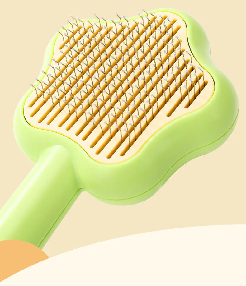 Green handle self-cleaning stainless steel needle comb for cats on a white background