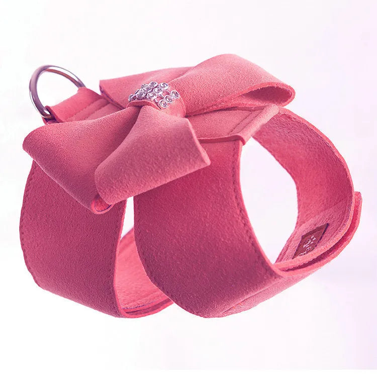 A pink microfiber puppy chest strap harness with a large bowknot, shown on a small dog.