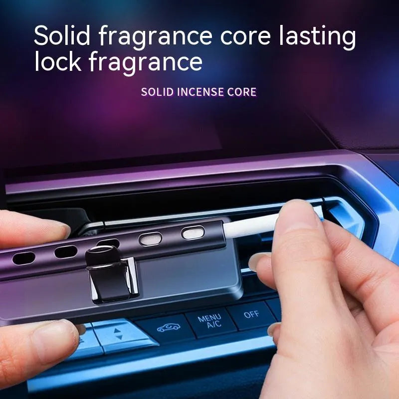 Black automobile aromatherapy LED light attached to a car air vent with a fragrance stick.