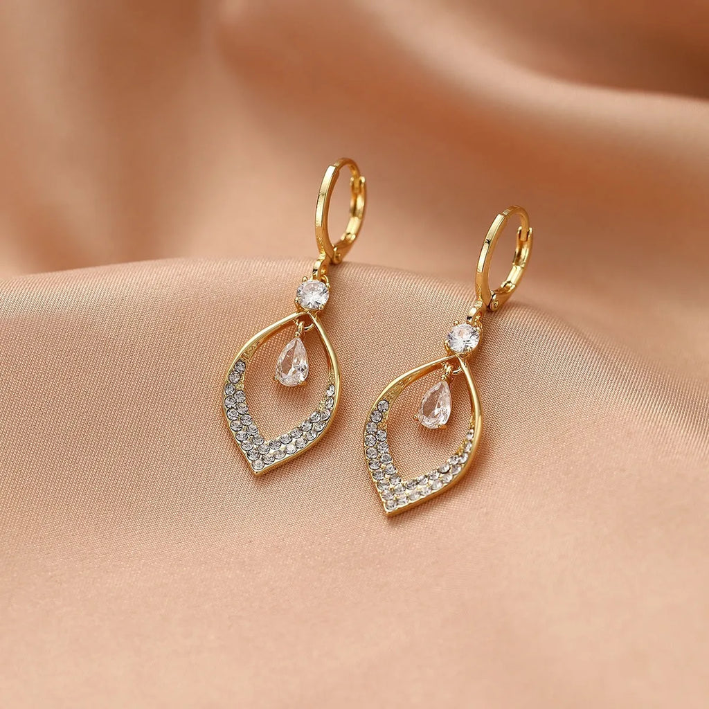 A pair of women's zircon teardrop tassel earrings with gold metal buckles on a white background.