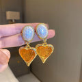 Purple, red, green, and yellow and white alloy pleated oval love heart stud earrings on silver posts.