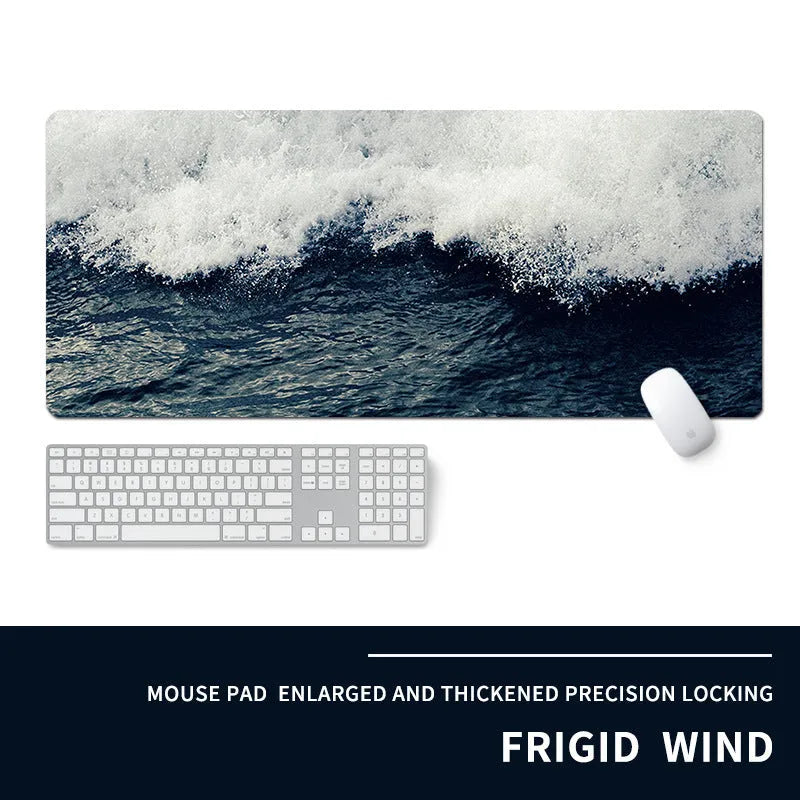 Oversized black gaming mouse pad with printed design and integrated raised wrist rest on a desk.