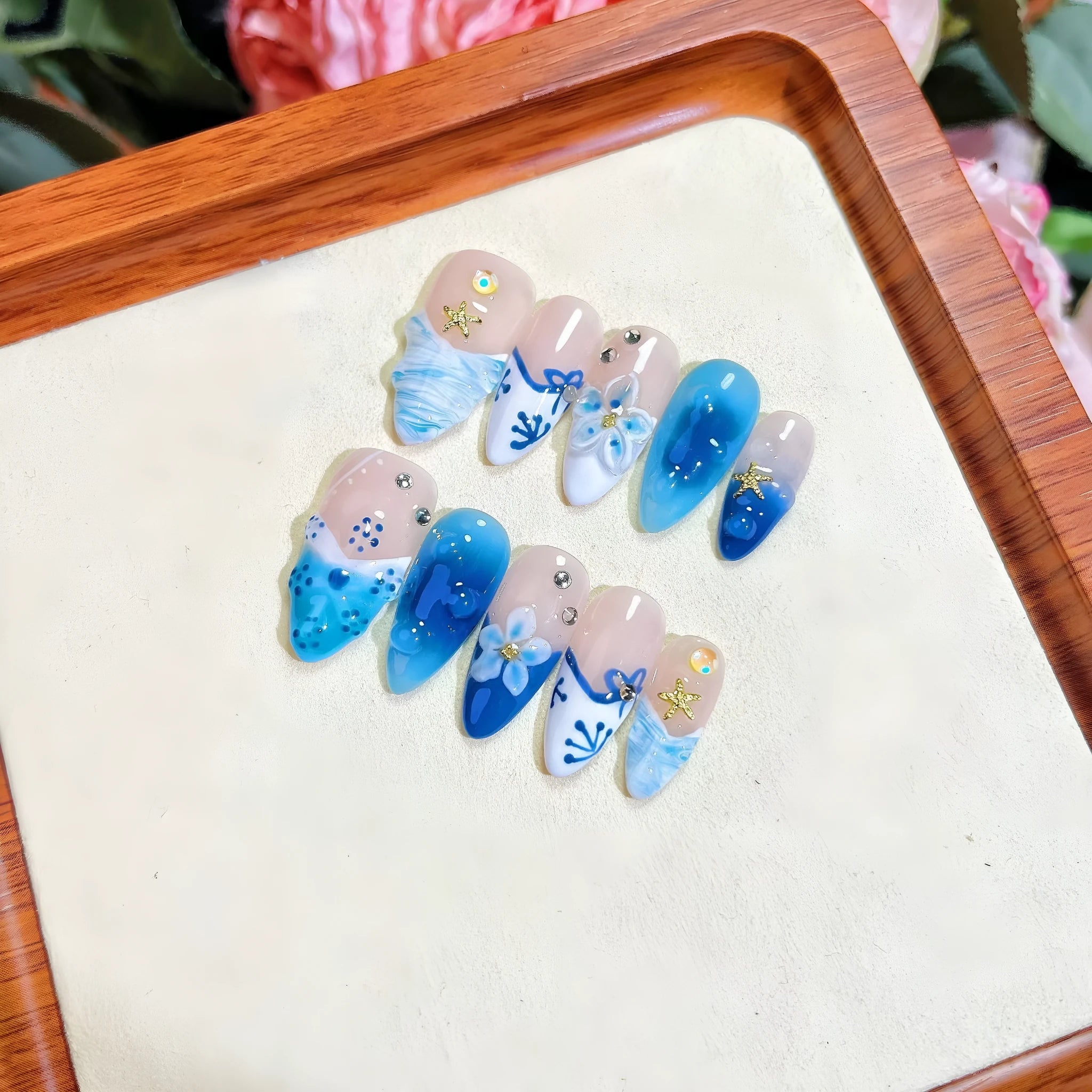 Blue hand-painted carved plastic fake nails set in sizes XS, S, M, L.
