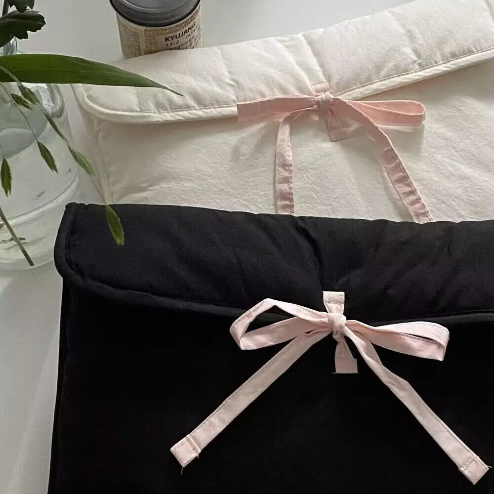 Women's black and white quilted nylon laptop bag with a ballet-style bow.