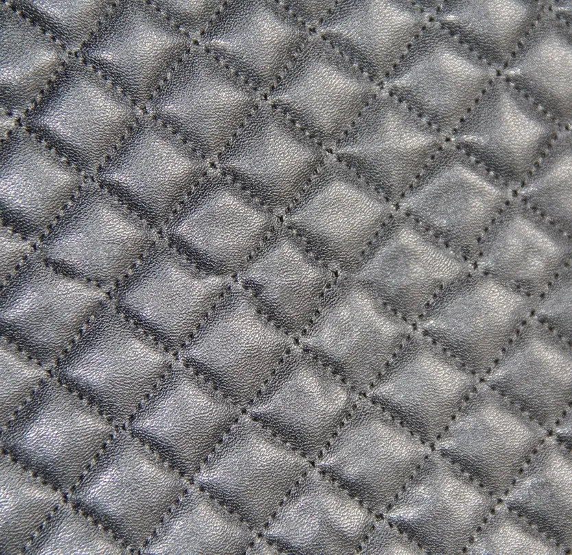 Black quilted automotive seat cover made from PU and polyester fabric on a car seat.