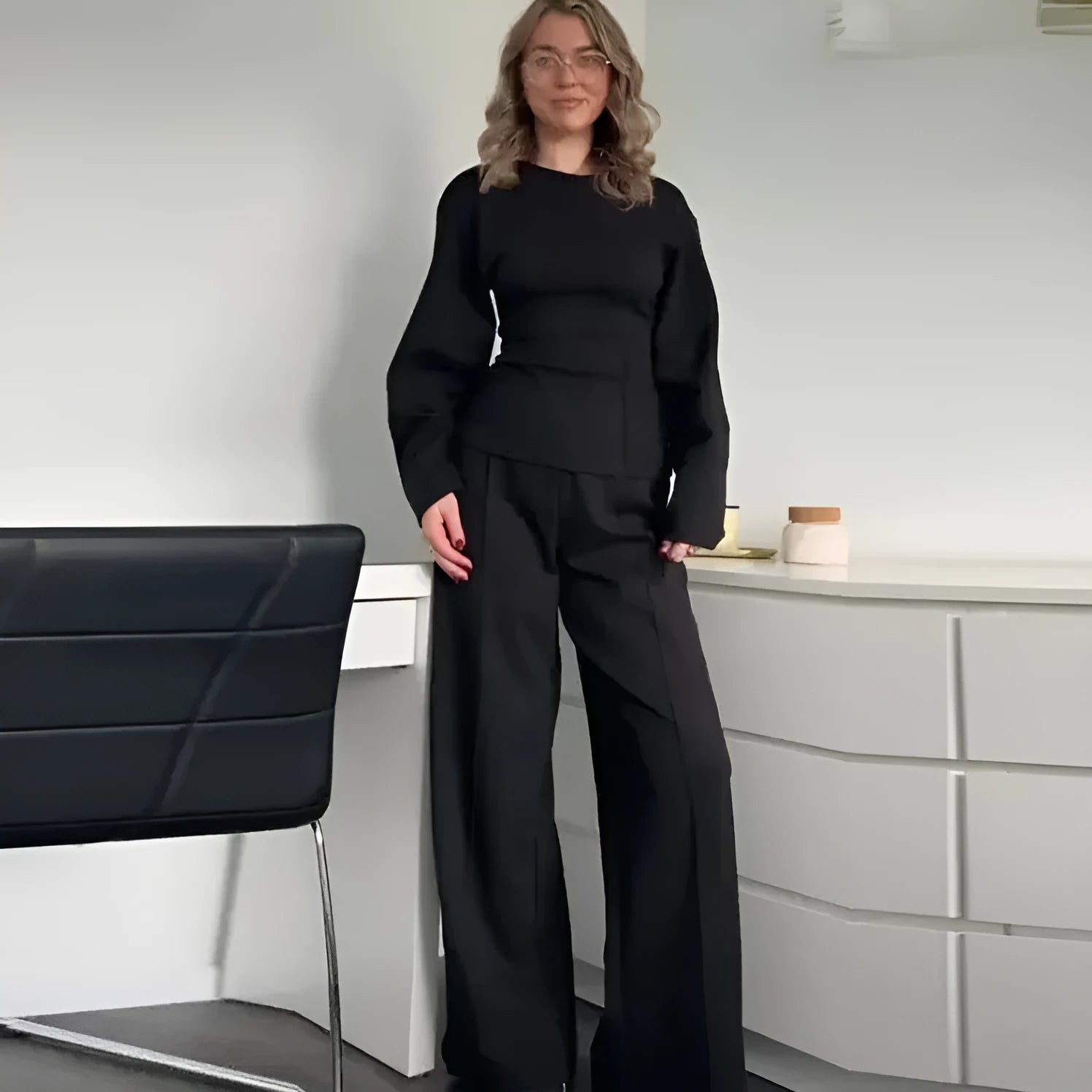 Women's polar fleece suit set with long sleeve O-neck top and wide leg pleated trousers in black.