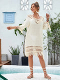 Apricot coloured hand-crocheted women's beach dress on a hanger.