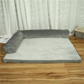 A corduroy dog sofa bed with raised sides, shown in a grey colour, placed on a wooden floor.