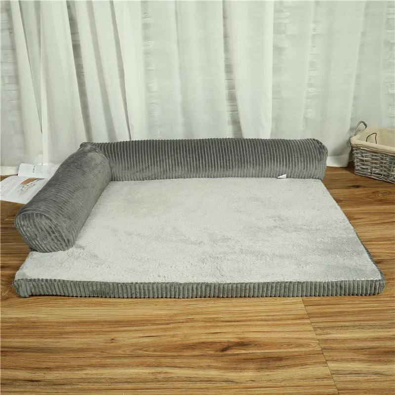 A corduroy dog sofa bed with raised sides, shown in a grey colour, placed on a wooden floor.