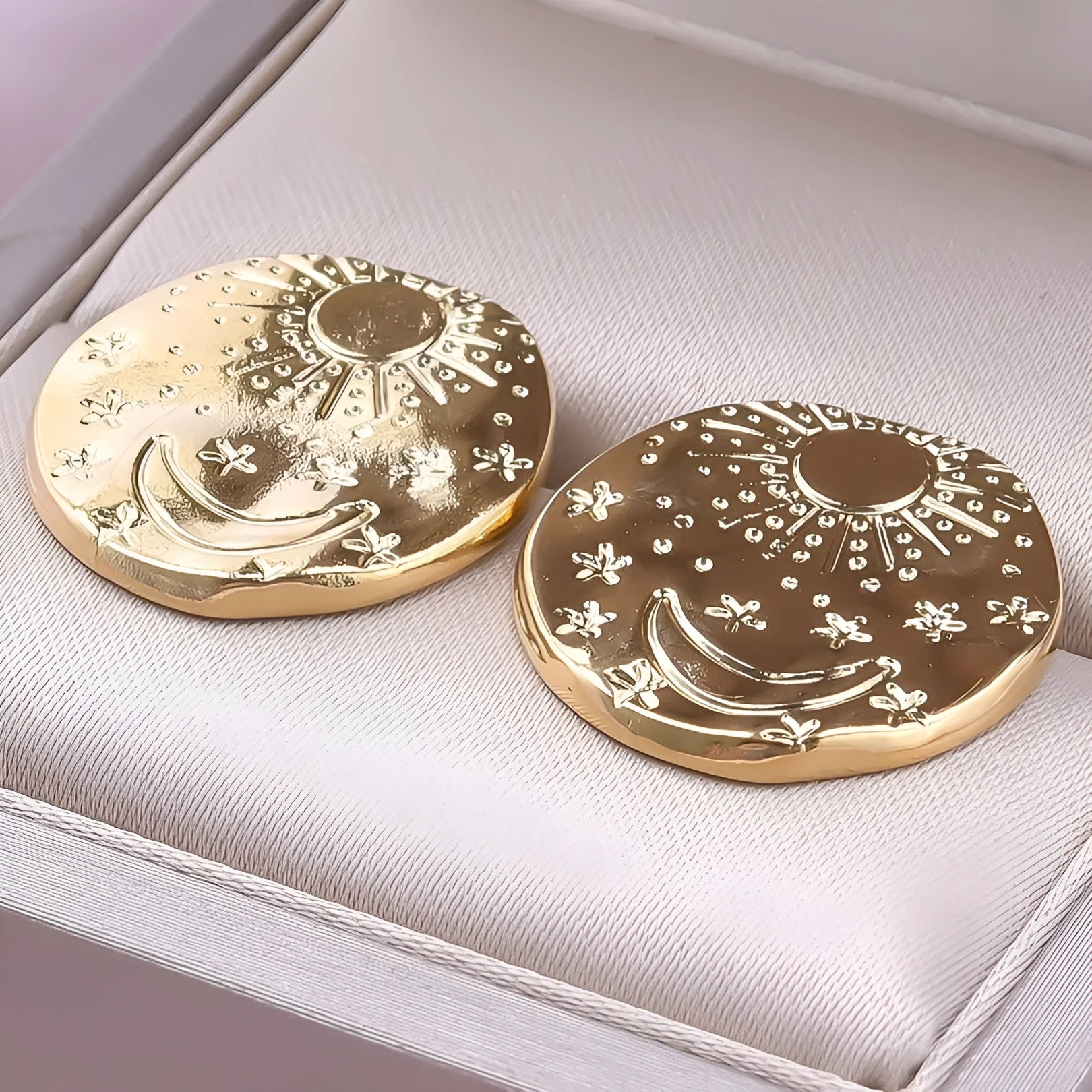 A pair of geometric stud earrings made from stainless steel with shell design details in gold colour finish.