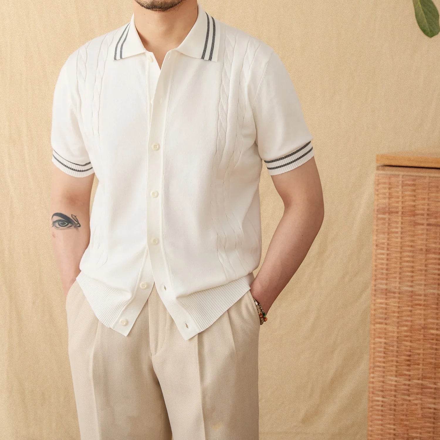 Man wearing a knitted apricot-coloured polo shirt with a lapel collar and short sleeves.