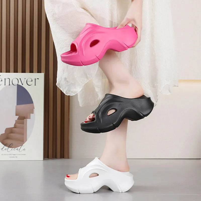 Women's thick-soled EVA slippers in rose red colour on a sandy beach background.