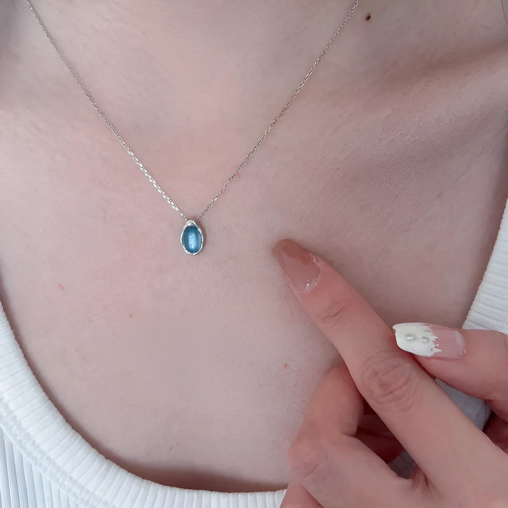 Navy blue geometric water drop necklace on adjustable cross chain, platinum-colour finish
