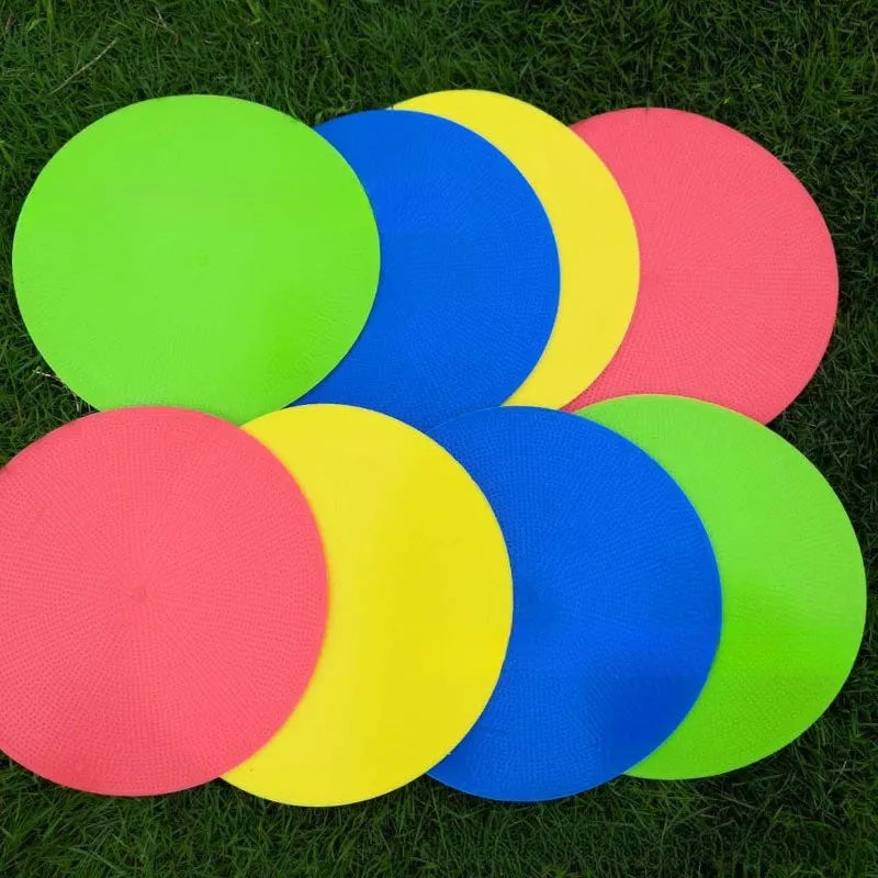 Soft TPE football training marker disc in yellow, 23 cm diameter, lying flat on grass.