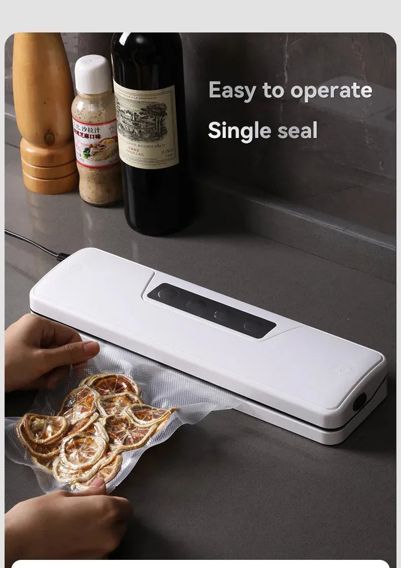 White compact automatic vacuum sealer machine for household food preservation on a kitchen counter.