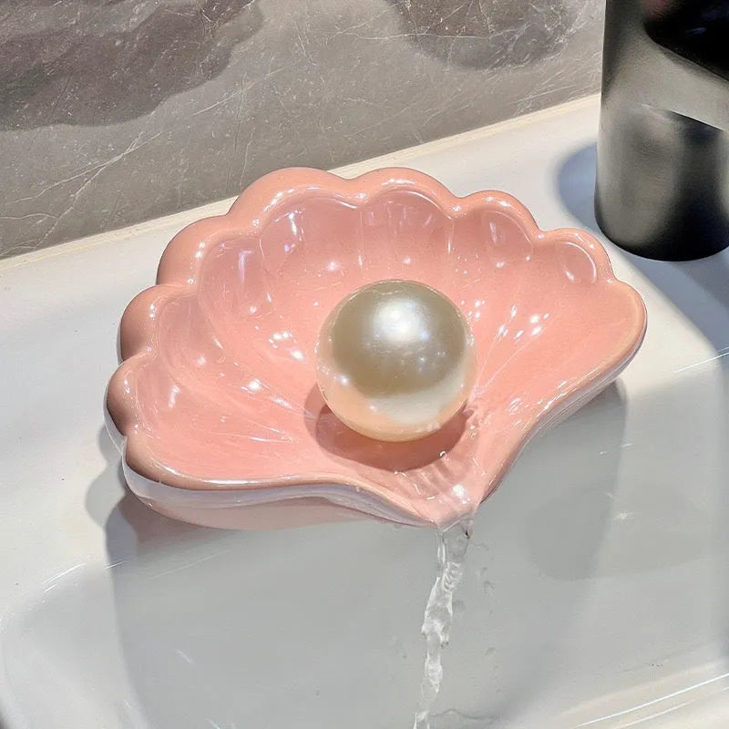 White and pink plastic shell-shaped soap dish for bathroom use