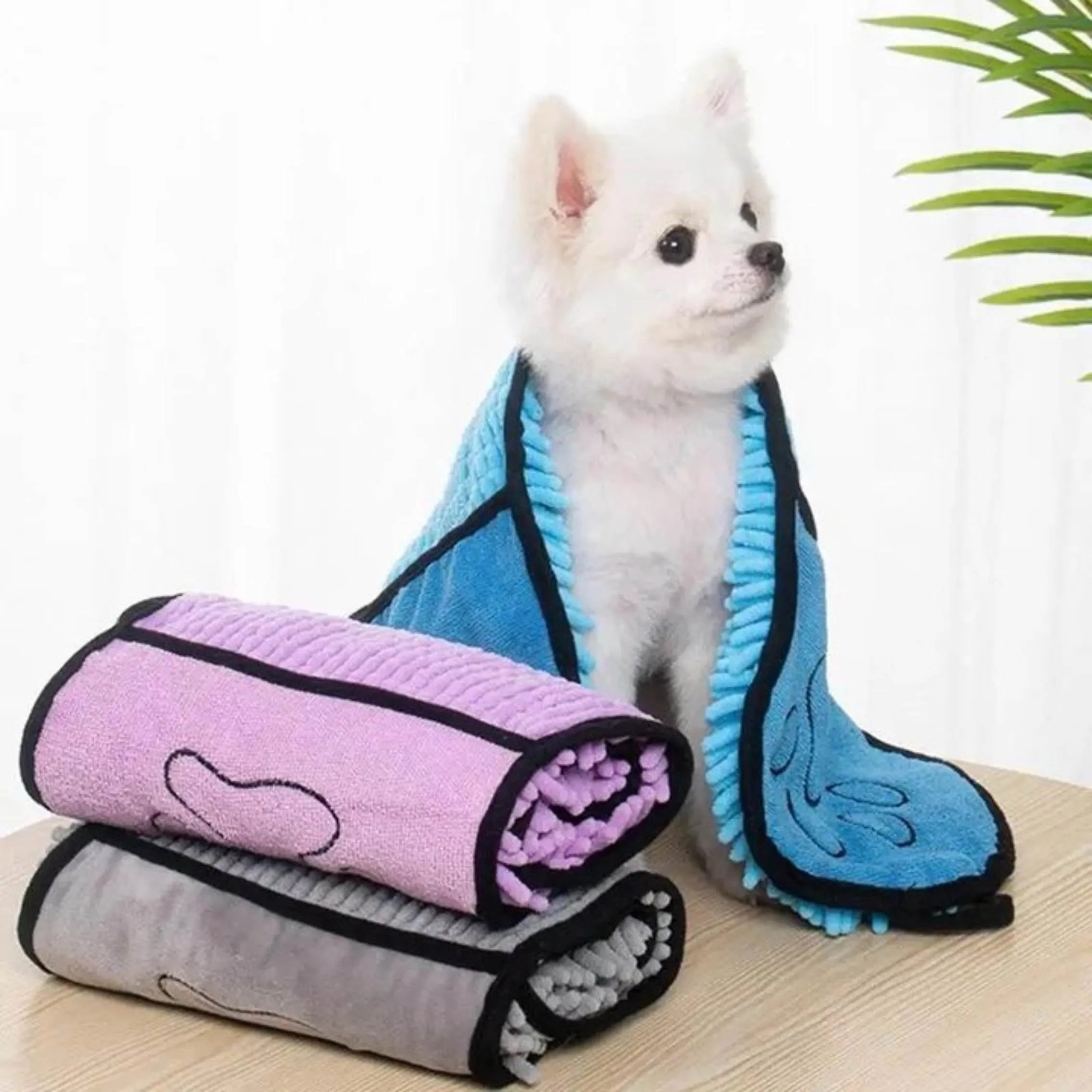Blue pet bath robe towel wrapped around a small dog, showing its size and absorbent fabric.