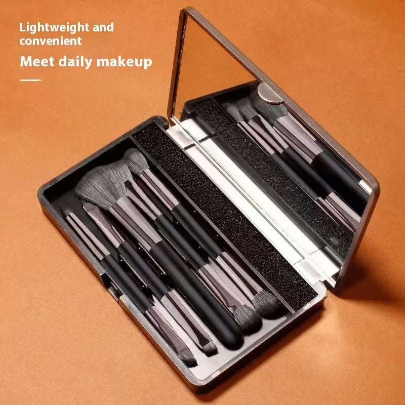 Makeup brush set with mirror showing artificial fibre bristles and plastic handles in portable packaging