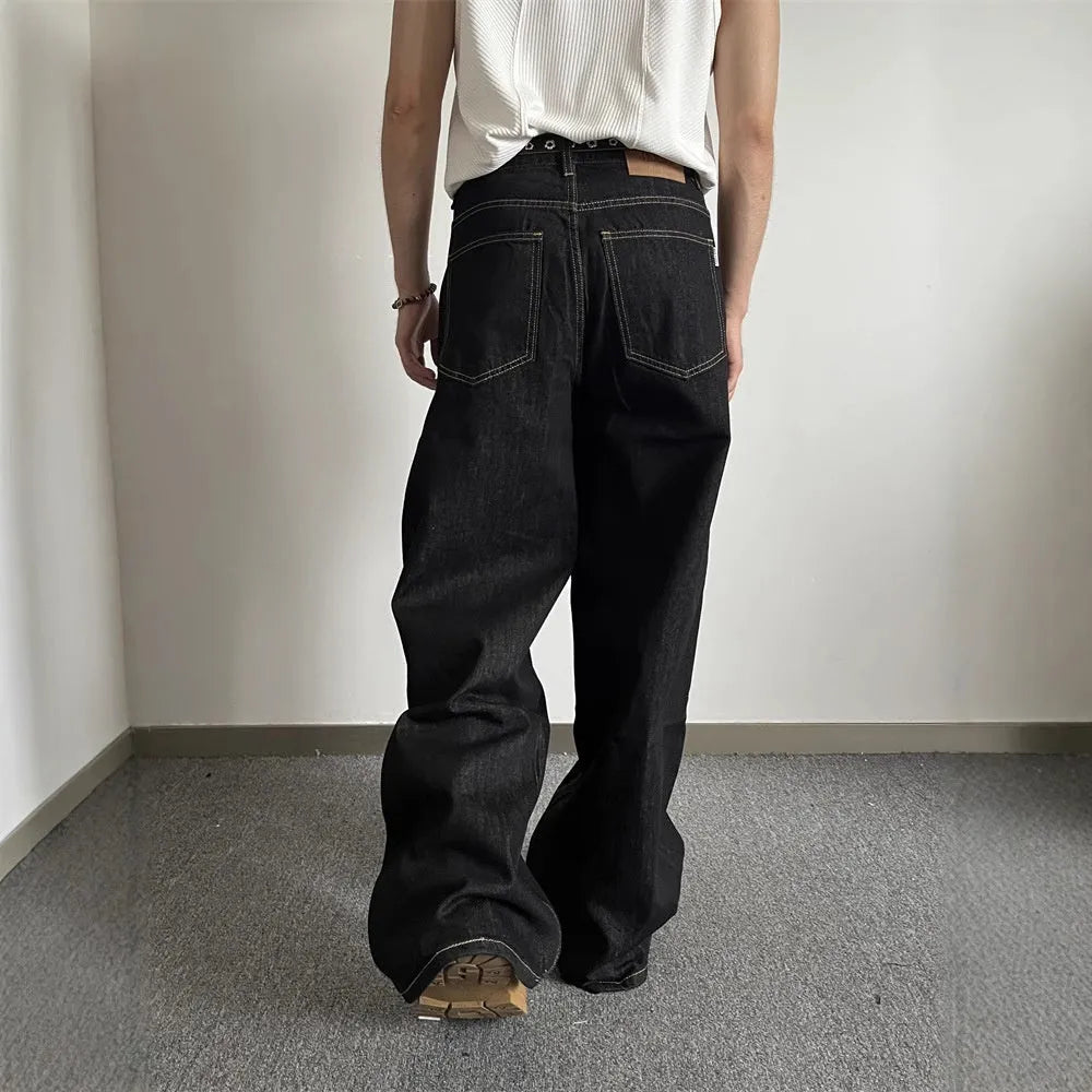 Black loose wide-leg retro jeans with a straight-leg cut and zip fly on a model.