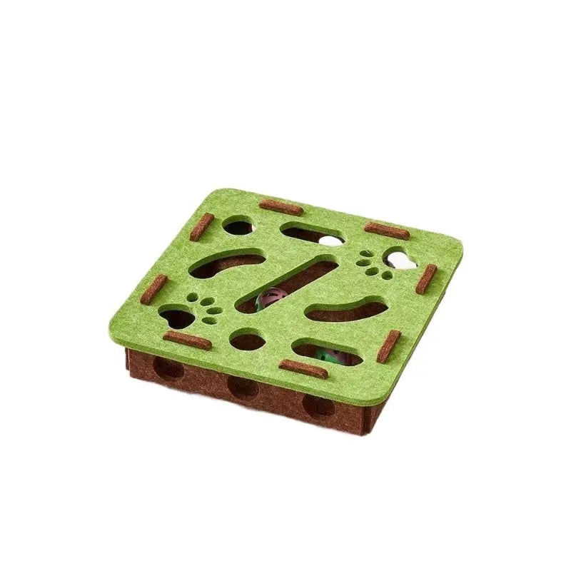 Rectangular green brown felt cat scratching box with holes, shown on a floor.