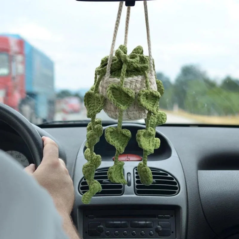 Green and white hand-knitted car plant ornament with a hanging cord on a basin-shaped base.