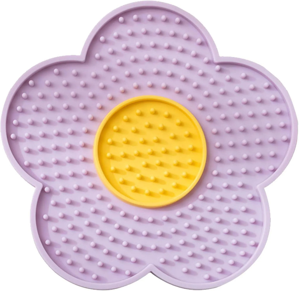 Flower-shaped blue silicone pet lick mat with suction cups on a smooth surface