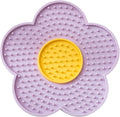 Flower-shaped blue silicone pet lick mat with suction cups on a smooth surface