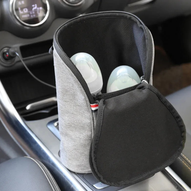 Grey portable car baby bottle warmer with dual slots and digital temperature display screen connected to 12V charger