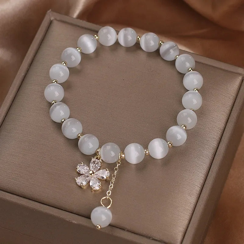 Women's white cat's eye stone bracelet with flower tassel detail and morganite safety buckle
