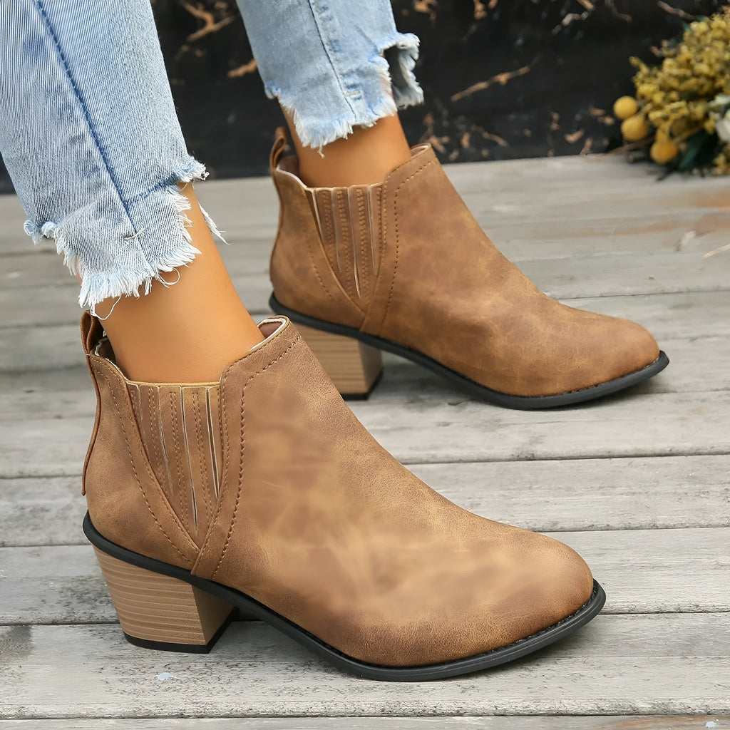 Women's black pointed toe ankle boots with a thick square low heel and slip-on design.