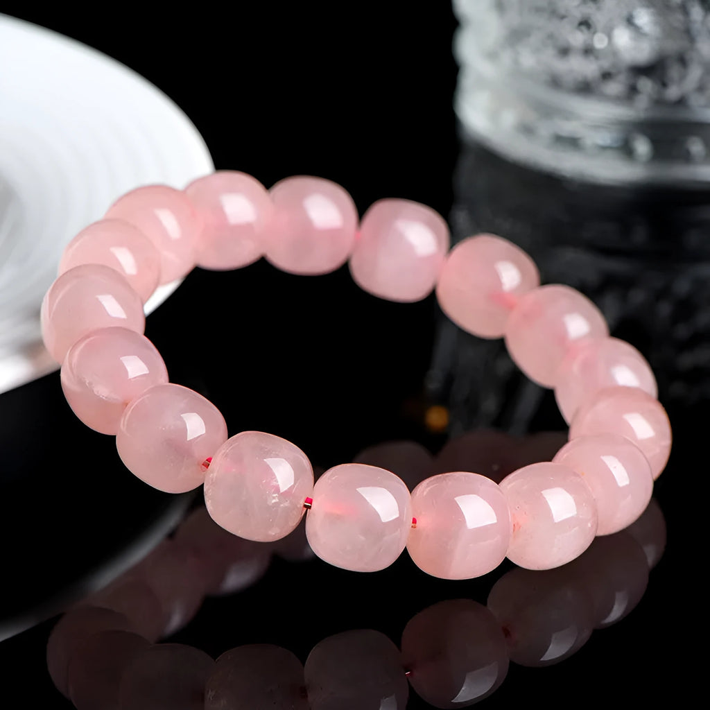 Pink natural crystal bracelet with barrel-shaped beads measuring 8 to 10 mm.
