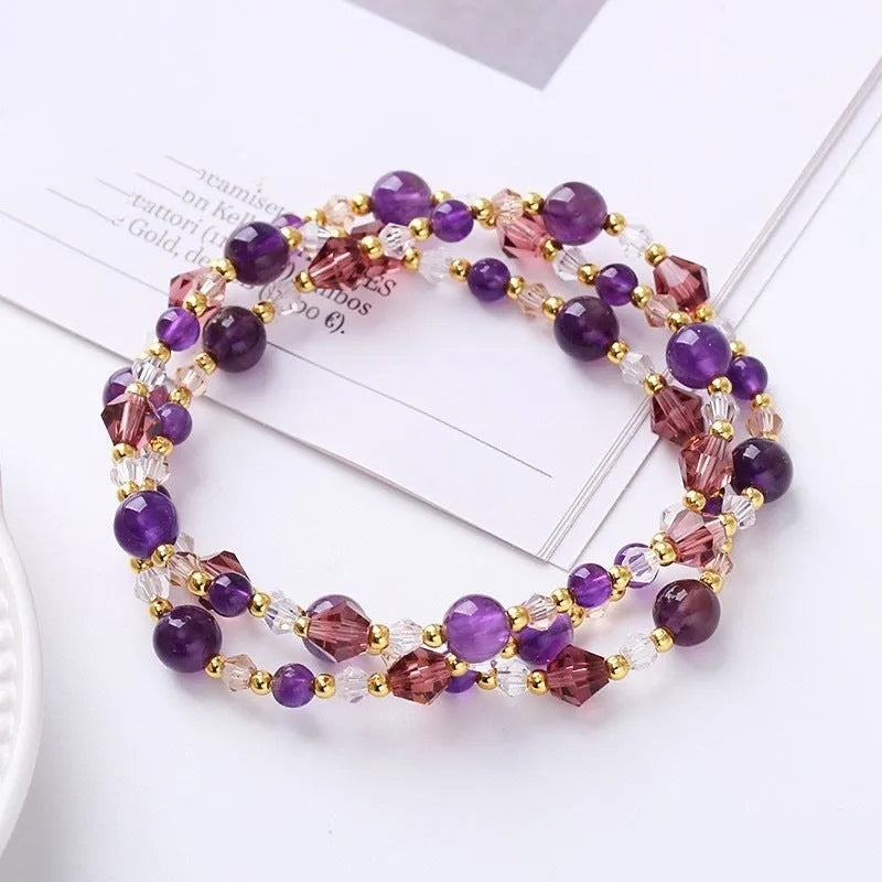 Handmade adjustable bracelet with three crystal rings: tourmaline, strawberry quartz, and amethyst.