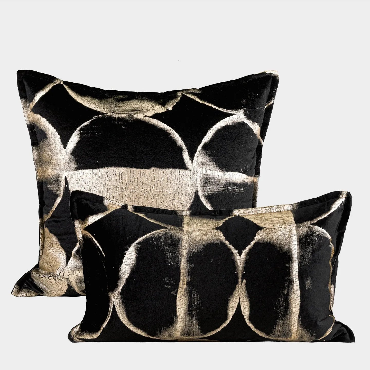 Abstract pattern black and gold decorative cushion pillow with removable cover on a grey sofa.