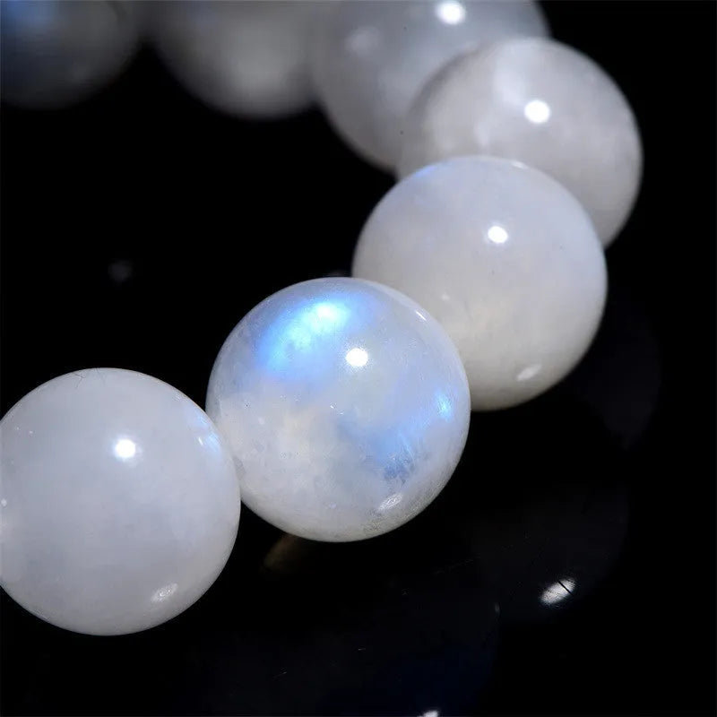 Natural blue moonlight round bead bracelet made from polished moonstone stones on a wrist.
