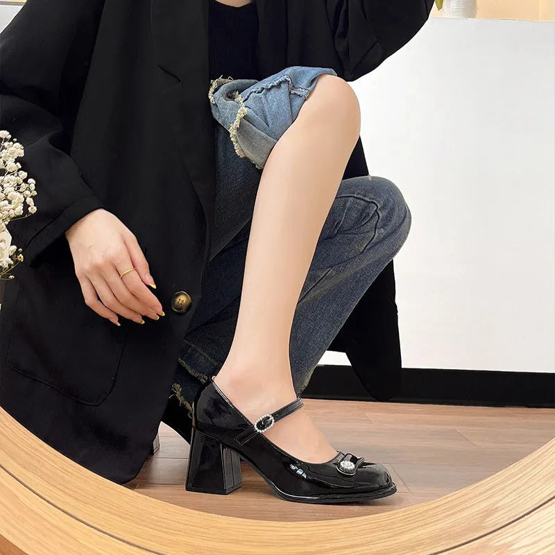 Women's black patent leather chunky heel round toe shoes with buckle fastening.