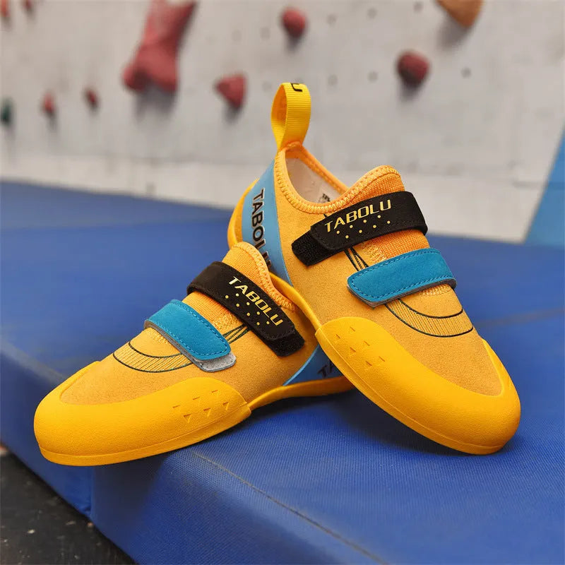 Beginner rock climbing shoes with Velcro strap and rubber sole in black and red colour combination