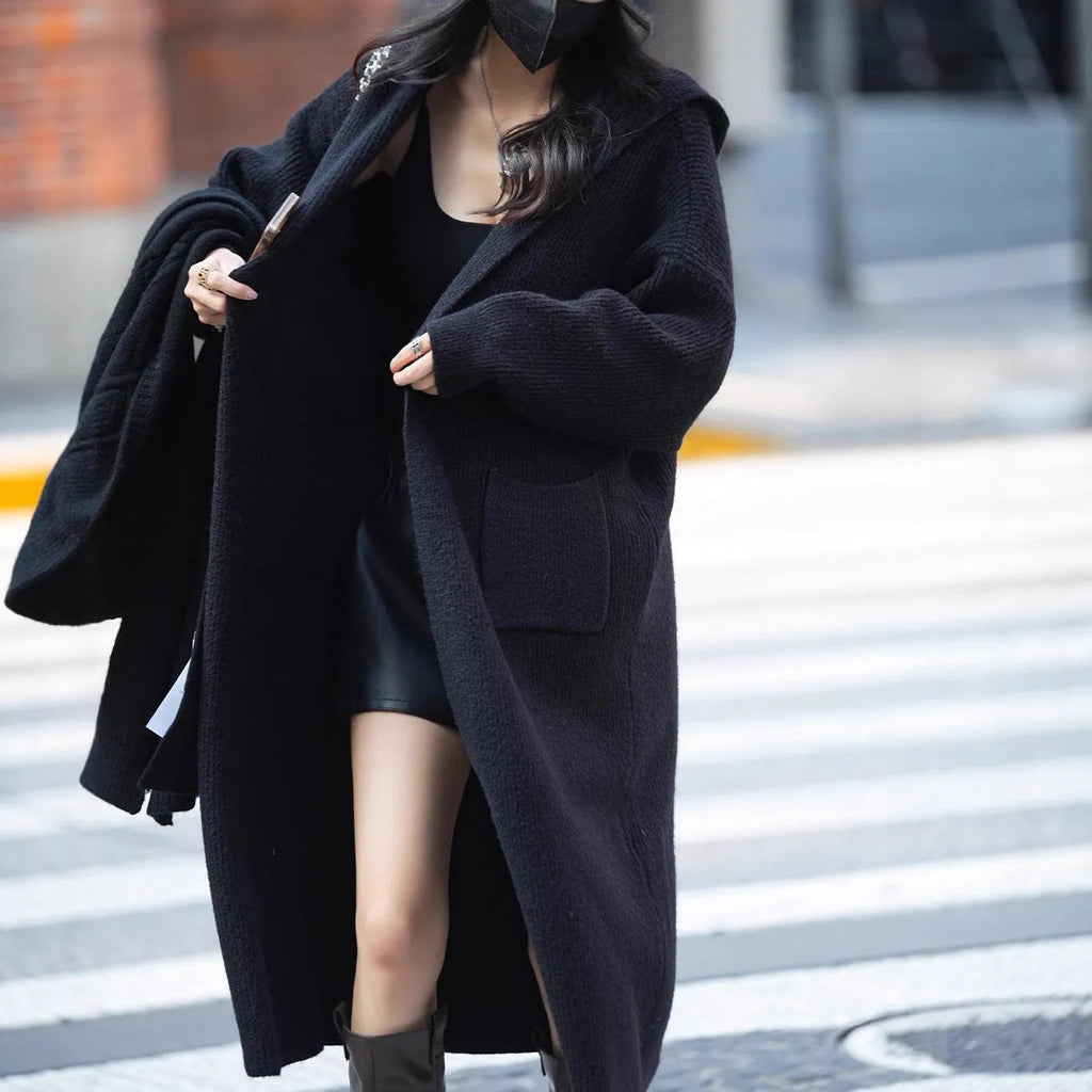 Long grey knitted cardigan trench coat with hood on a hanger.