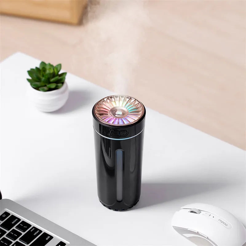 Black portable car humidifier with colourful LED lights on car cup holder showing mist output
