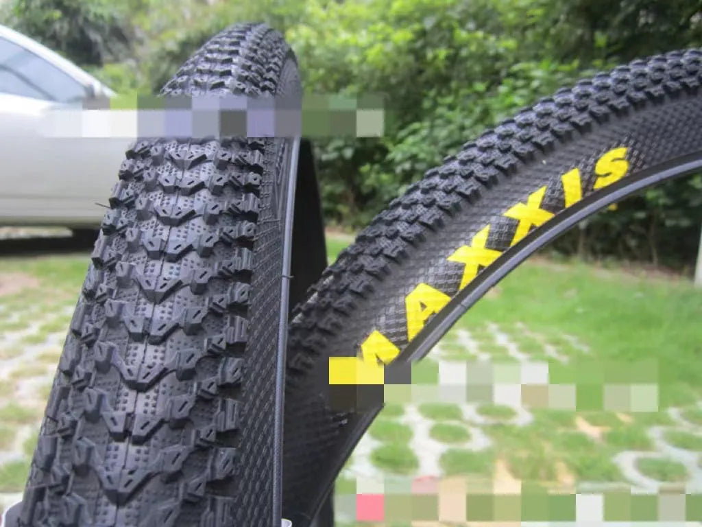 Ultralight black mountain bike tyre with white label sidewall option on a trail.
