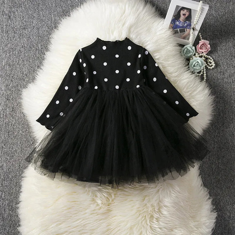 Baby girl wearing a long sleeve black tutu dress with lace detail, suitable for a party or casual wear.