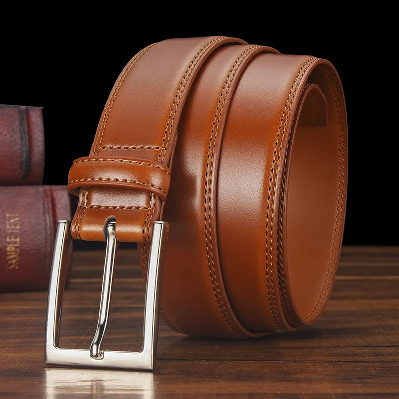 Men's classic black patent leather belt with a silver pin buckle on a flat surface.