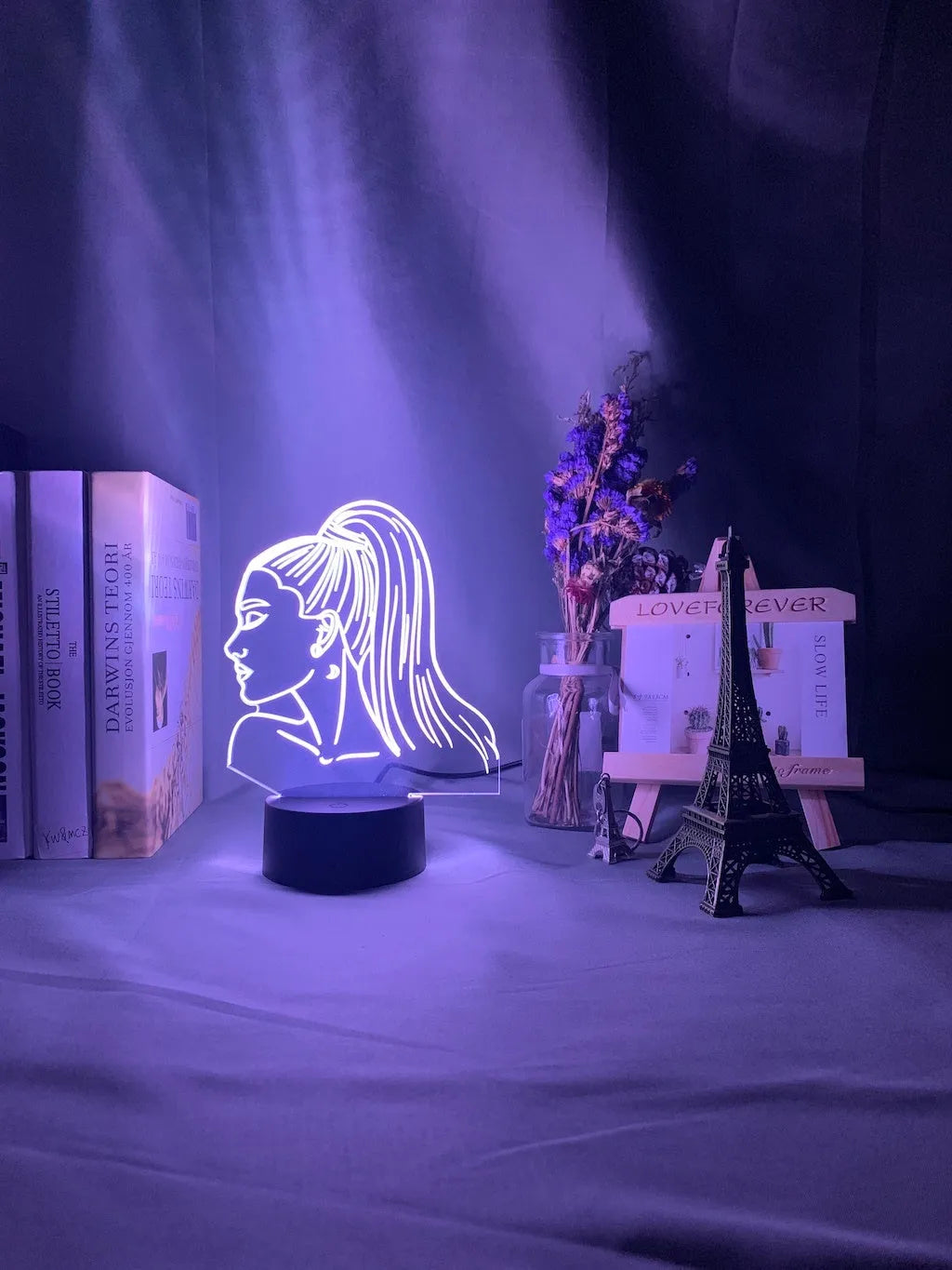 Slim white acrylic 3D decorative night light with LED illumination and remote control on a table.