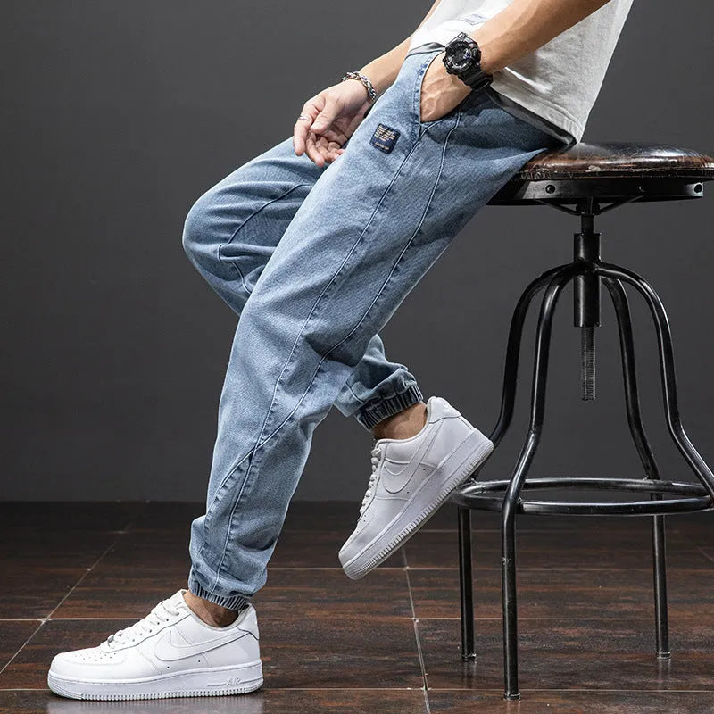Men's loose fit blue cargo jeans with straight leg and cargo pockets on a plain background.