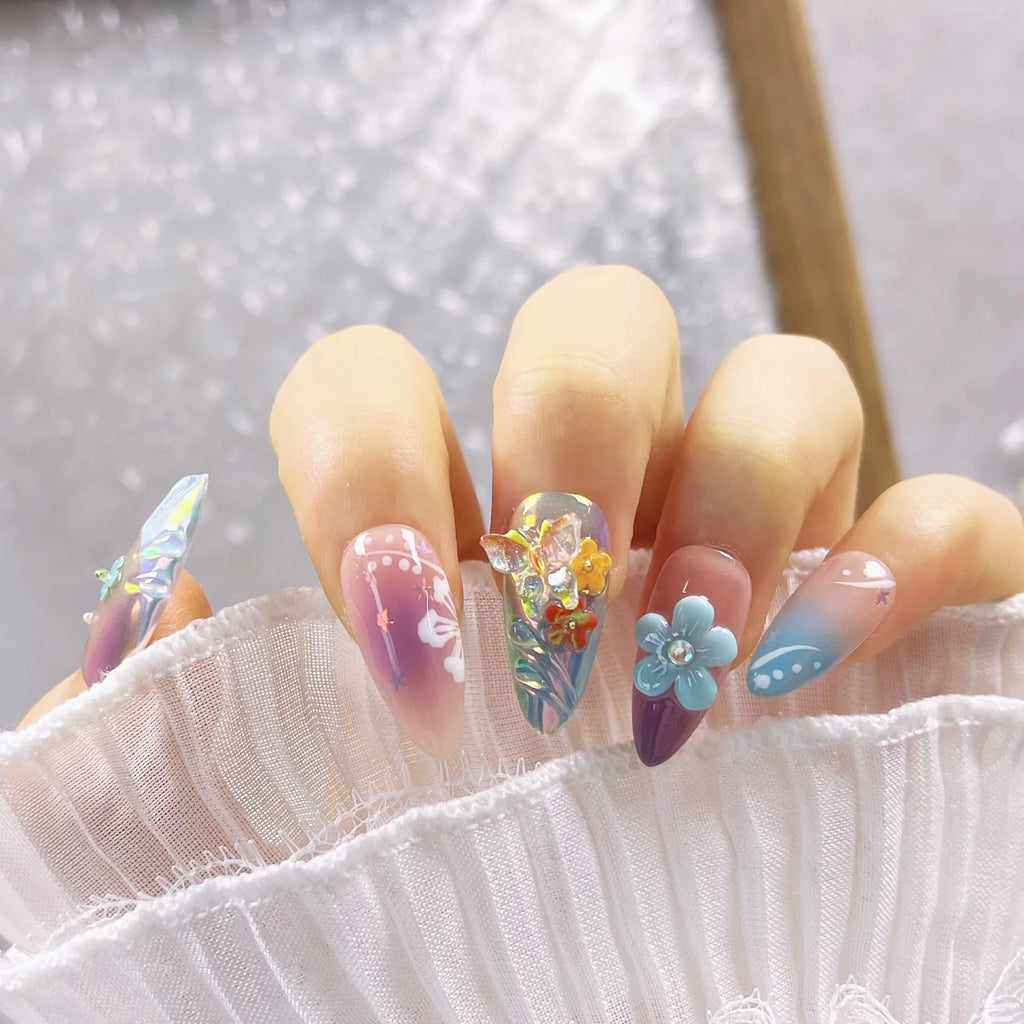 Handmade 3D nail art sculpture of embossed flowers and butterflies on an almond-shaped base.